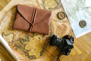 a black camera and leather case over a world map